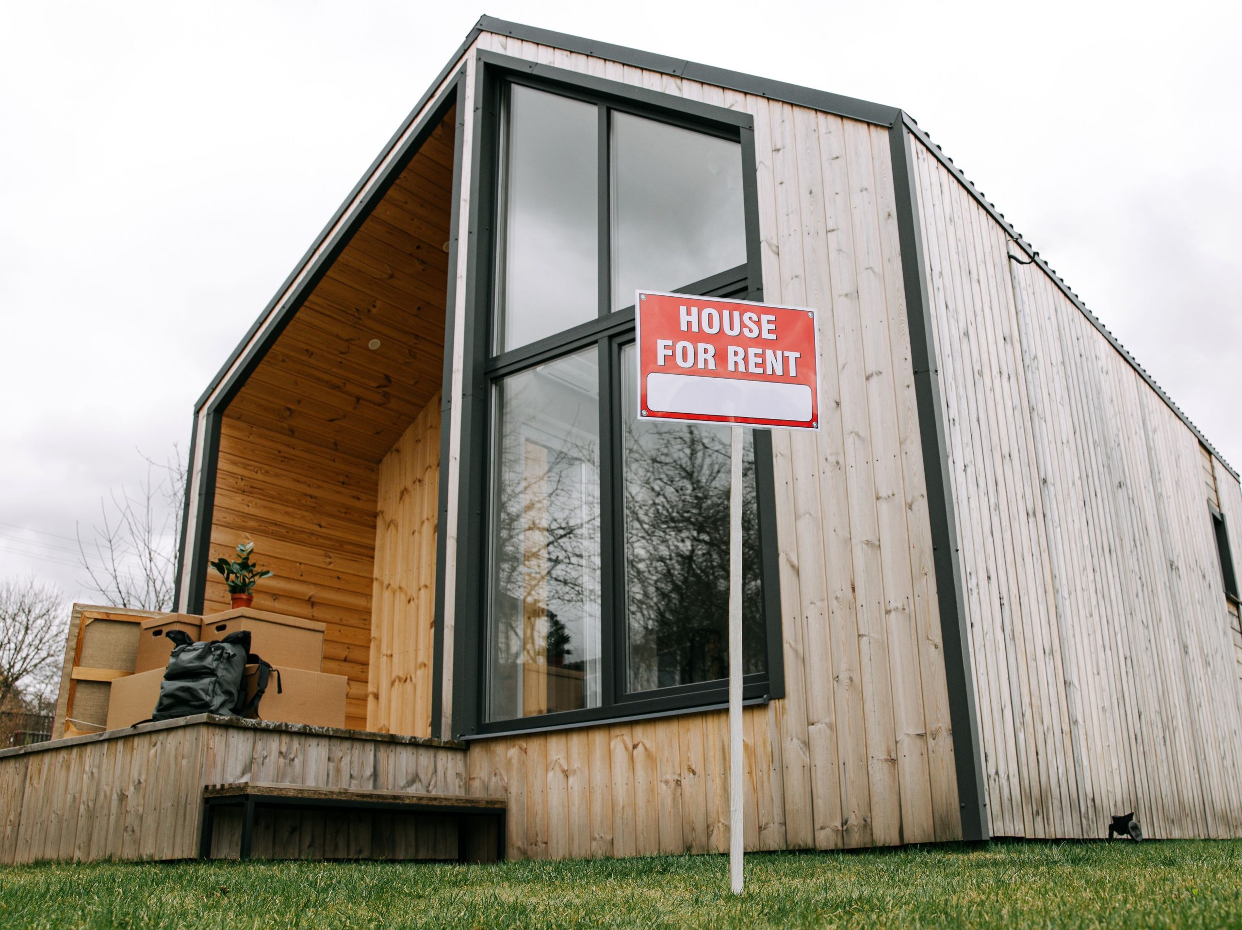 Modern rental property with a house for rent sign representing a home equity rental investment.